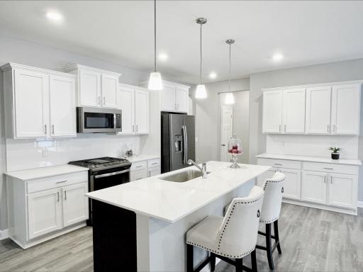 Photo of similar home, colors and finishes will vary. One level living! This dream kitchen features plenty of cabinet space, an oversized center island, quartz countertops, tile backsplash, walk-in pantry and the popular slate finish appliances!