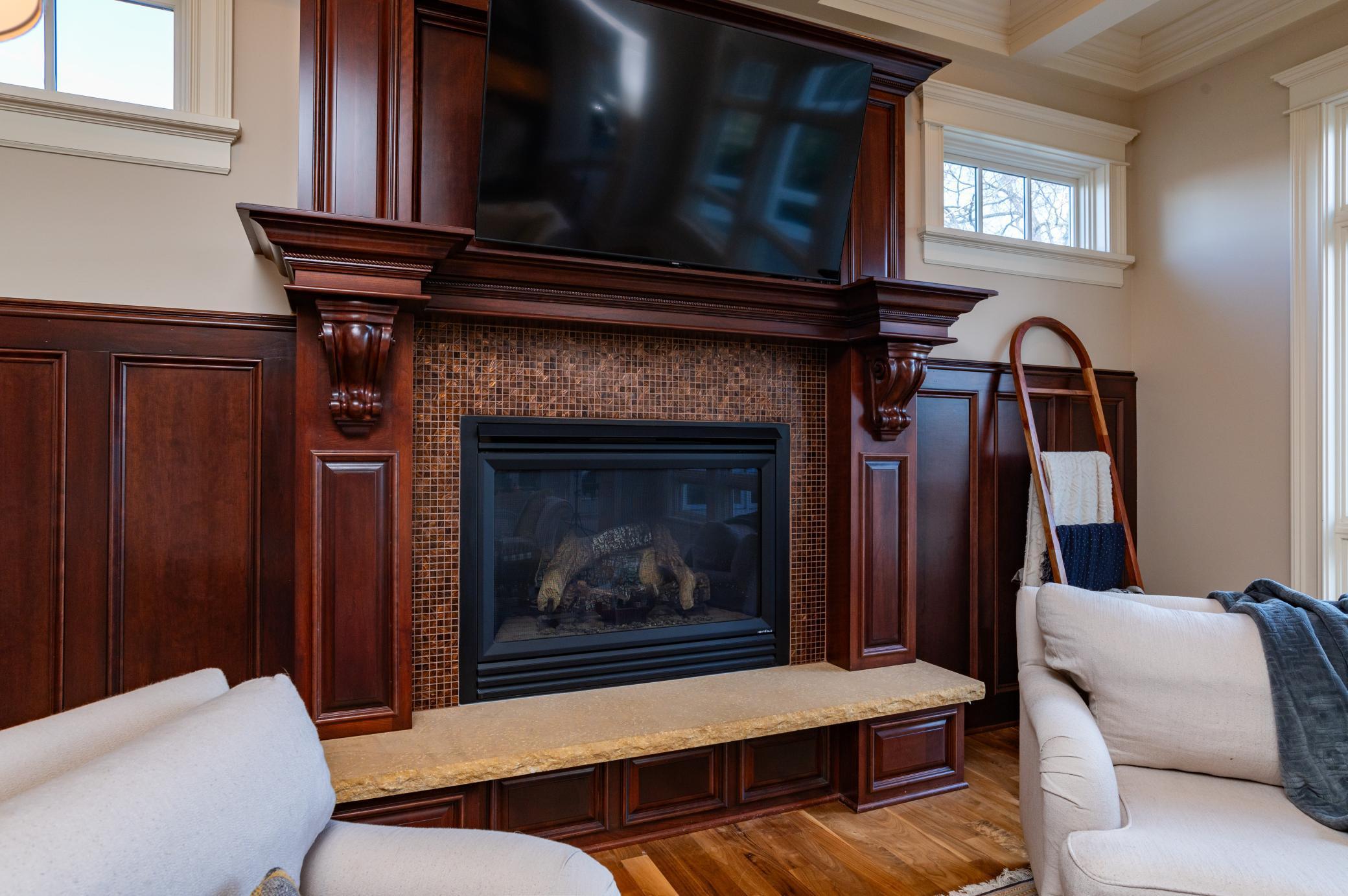 Gas Fireplace in Great Room with Custom Cabinetry, Stone Hearth and Glass Tile Surround