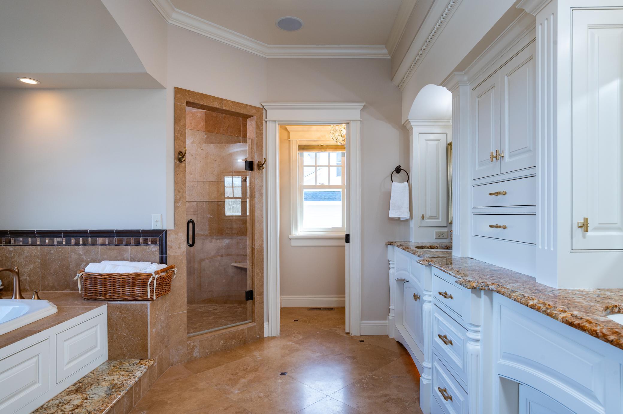 Heated travertine floors, Dual Vanity, Brushed Brass Hardware, Updated Lighting and Double Shower