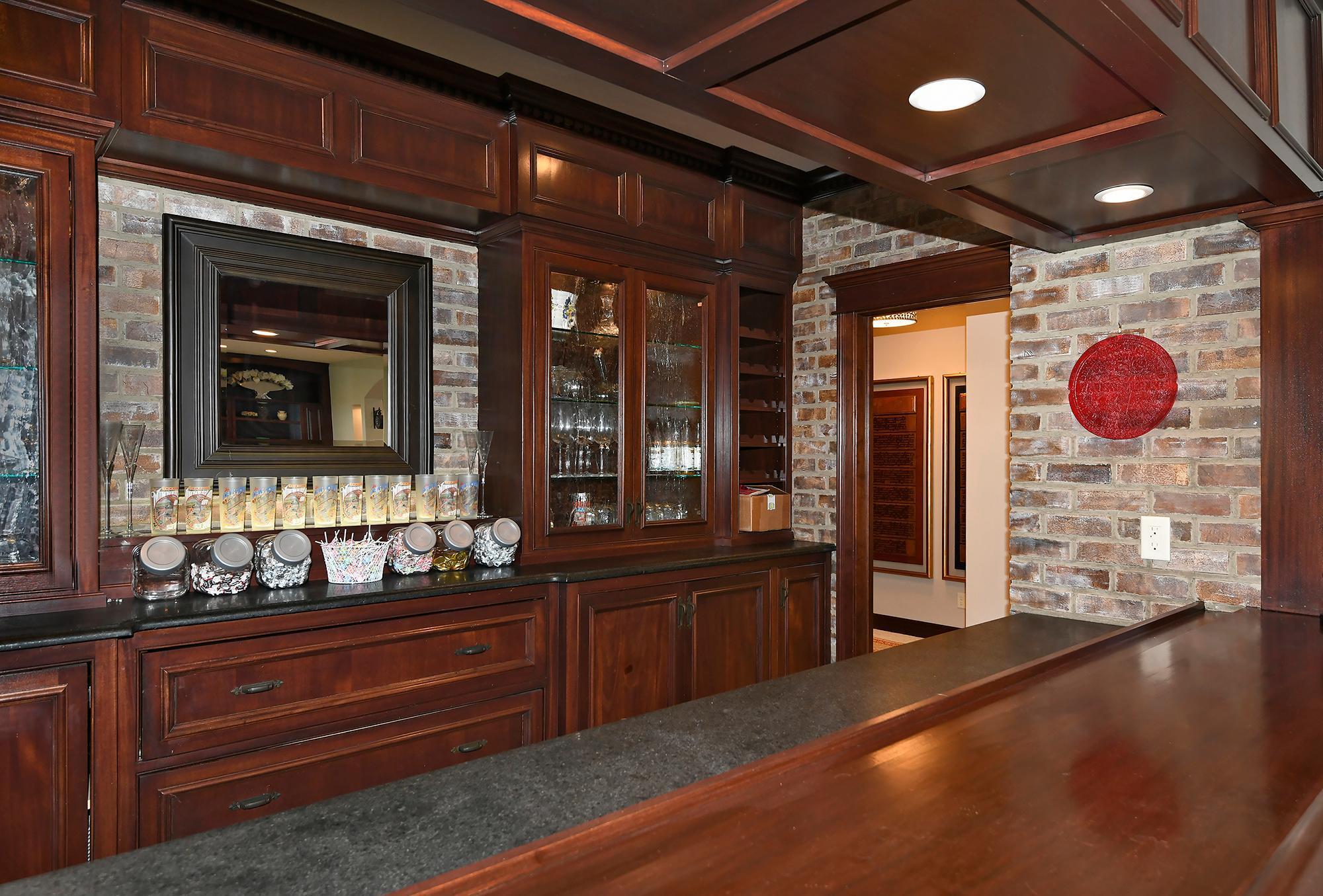 Back-lit Cabinets with Brick Walls, Honed Granite Counters, Seeded Glass Cabinet Doors & Wine Rack