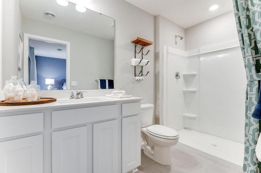 Private en suite bathroom off primary with double vanity and walk-in shower. (Model photo, colors may vary)