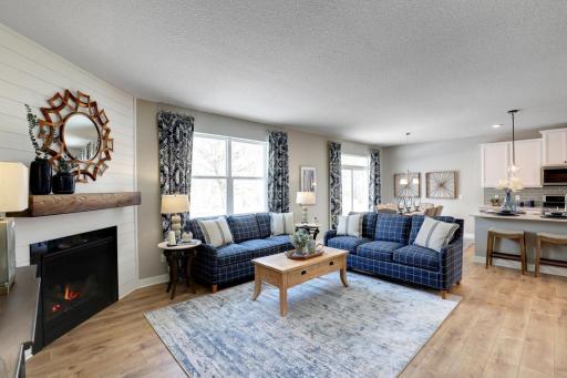 The spacious main level family room features a corner gas fireplace with mantle! *photo of model with same floor plan. Selections will differ.