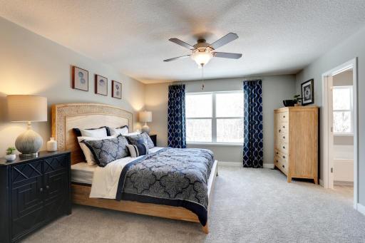 An oasis on it's own, the primary suite is both open and expansive, and is connected to a spacious primary suite bath and an oversized walk-in closet. *photo of model with same floor plan. Selections will differ.