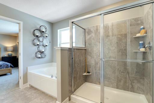 The primary suite bathroom boasts a separate shower and large soaking tub! *photo of model with same floor plan. Selections will differ.