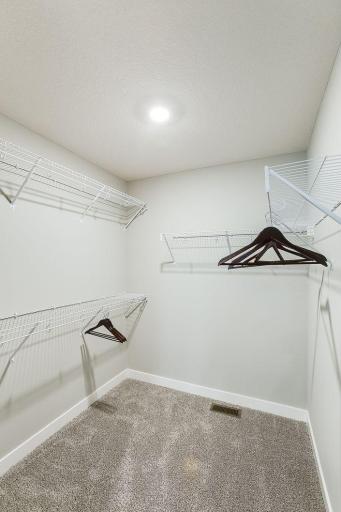 One of two primary sweet walk-in closets. Model photo. Options and colors will vary.