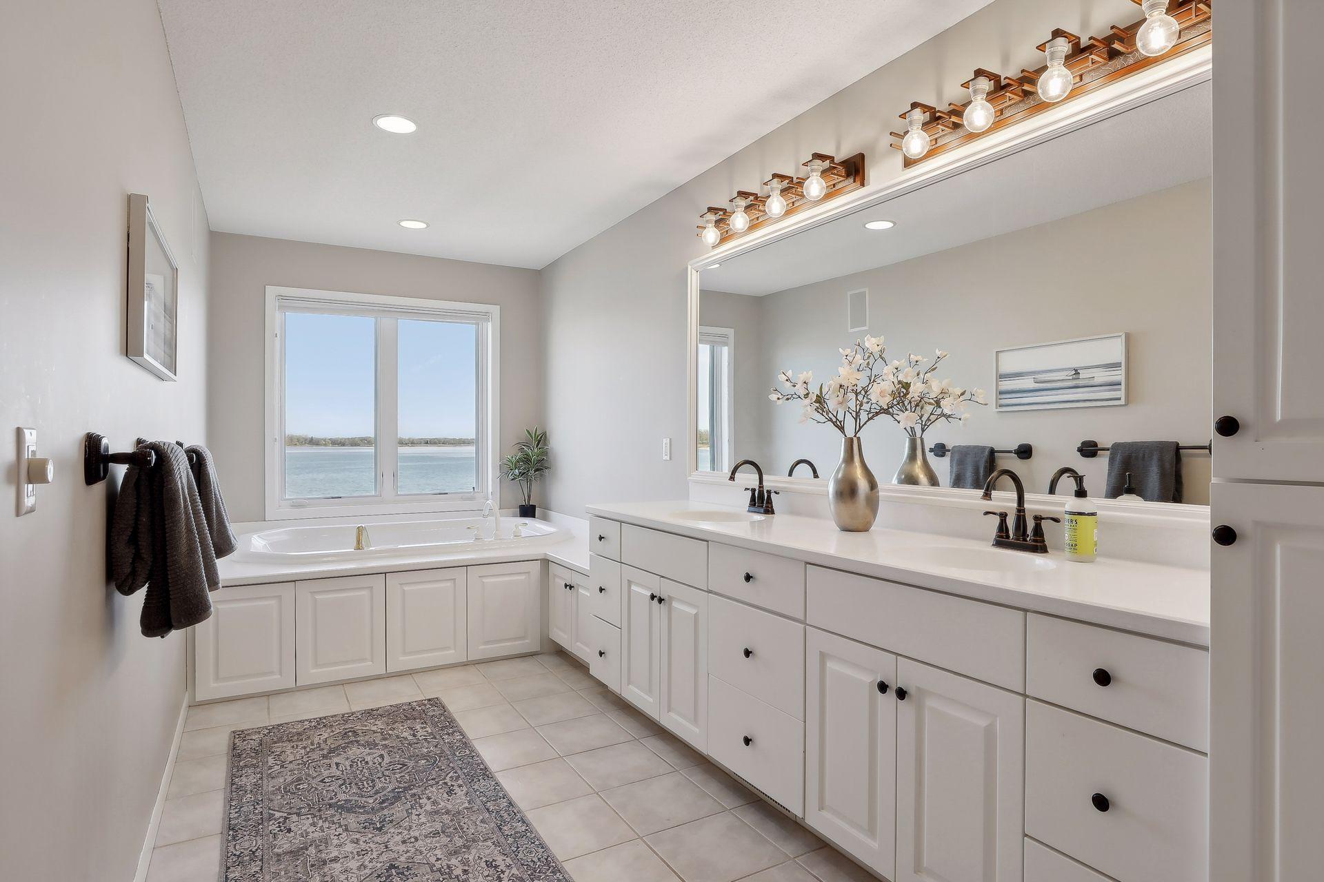 Luxury bath with double sinks, ceramic tiled floors. Don't miss the lake view while chilling in the jacuzzi tub!!