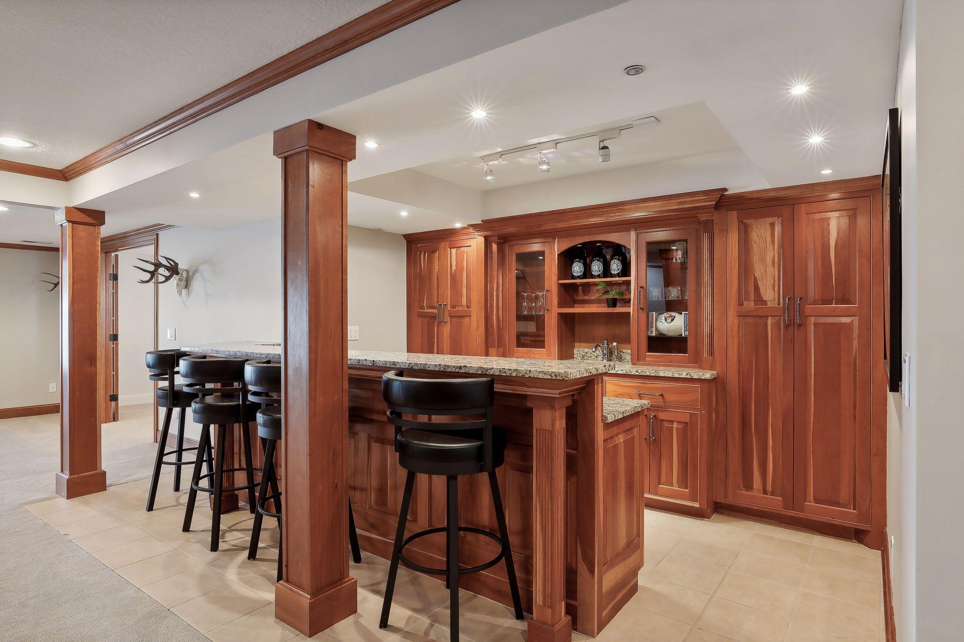 Fabulous lower level bar! Tucked behind is some extra hidden storage room. All that is needed is your for guests to Belly Up To The Bar!