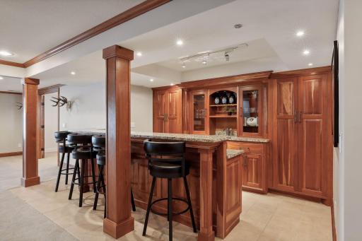 Fabulous lower level bar! Tucked behind is some extra hidden storage room. All that is needed is your for guests to Belly Up To The Bar!