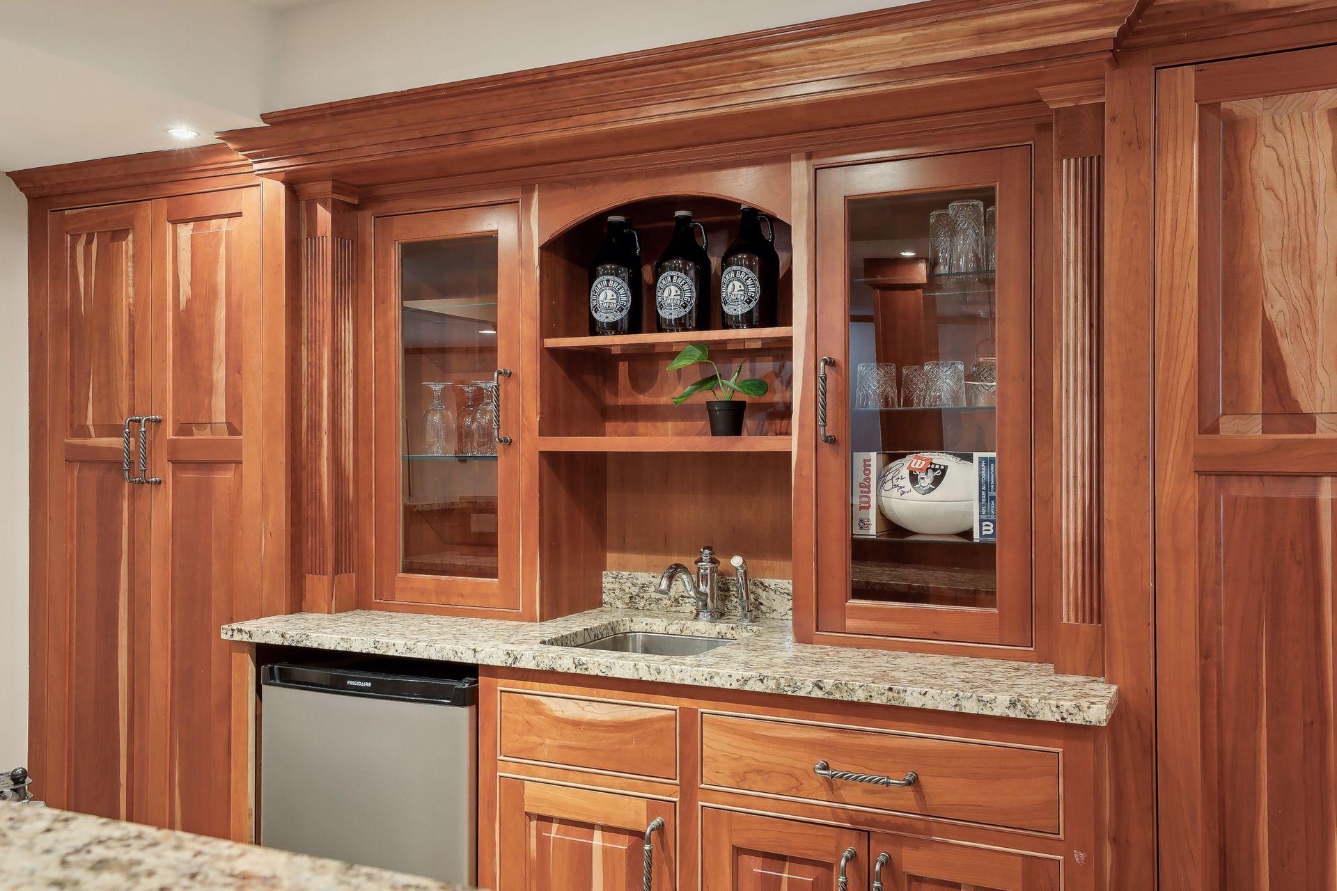 Elegant wet bar, glass cabinets, Granite Countertops and beverage fridge.