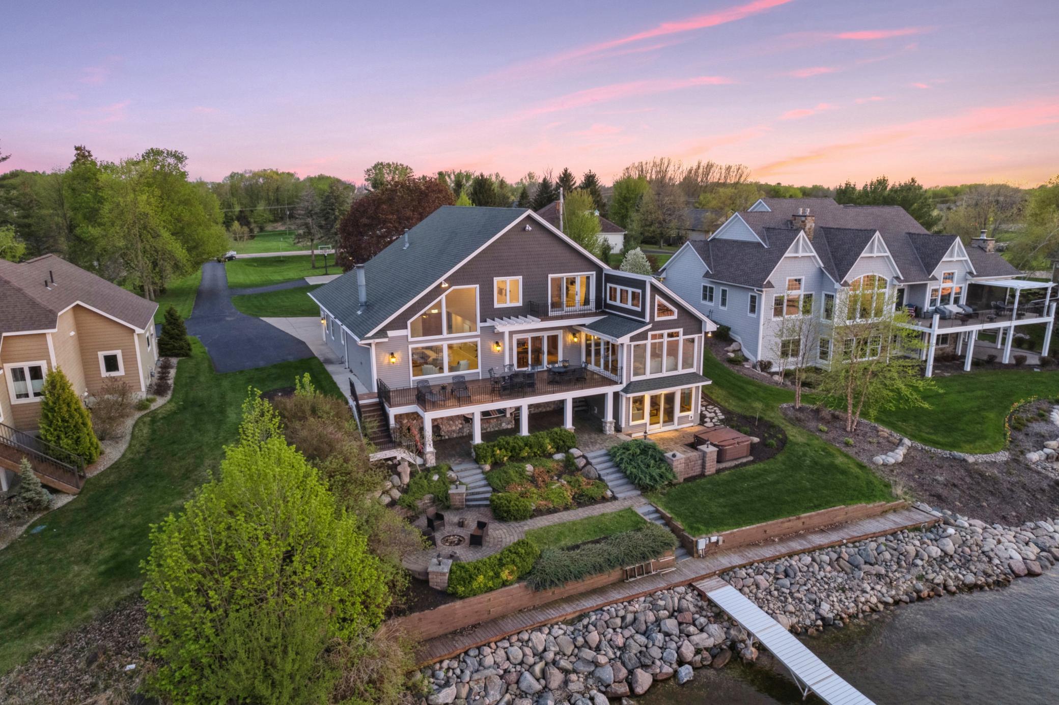 Don't miss this spectacular setting! Beautifully landscaped, level setting! Easy outdoor entertaining with paver patio, firepit area, sprawling deck, dock, and so much more! All you need to do here is GO JUMP IN THE LAKE!