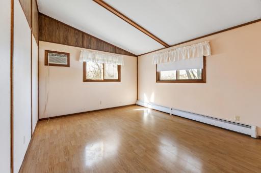 The second bedroom also features abundant natural light with vaulted ceilings and gleaming floors. Neutral colors make this space ready for any style decor.
