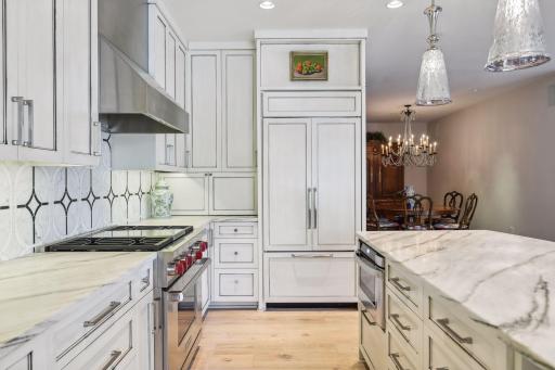 Granite countertops, tiled backsplash, high-end appliances, plus a pantry and cabinet space for storage are highlights of the kitchen