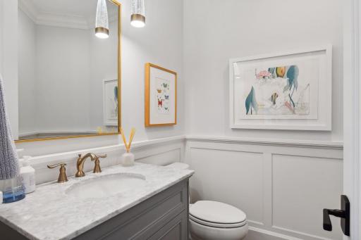 An elegant Powder Room â finished with a furniture-style vanity, enameled wainscoting and designer fixtures.