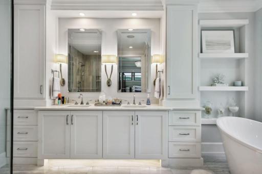 The spa-worthy Primary Bath offers extensive cabinetry with accent lighting and quartz countertops and heated tile flooring.