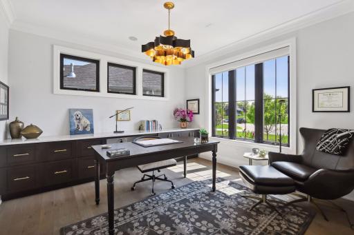 Adjacent to the foyer, the Home Office is a sophisticated space with designer lighting and a built-in bank of file drawers and cabinetry topped with quartz. Working from home has never been so relaxing.