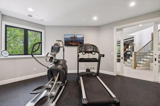 Nestled behind a set of sliding barn doors, the Exercise Room offers two walk-in closets, a mirrored wall and rubber gym flooring. This space could easily be converted into a fourth bedroom.