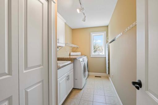 Experience the ultimate in convenience and efficiency with the upstairs laundry room. Boasting a utility sink and ample cabinets for storage, this well-appointed space offers the perfect blend of form and function for all your laundry needs.