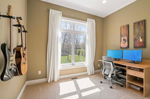 Offering the flexibility to function as a bedroom or an office, this inviting room boasts serene views of the backyard, providing the perfect backdrop for productivity or relaxation.
