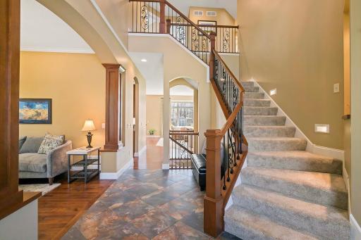 The foyer features exquisite tile flooring that adds a touch of refinement to the space. With its graceful curves, ornate railing, & commanding presence, the staircase serves as a focal point of the foyer, adding a sense of drama & elegance.