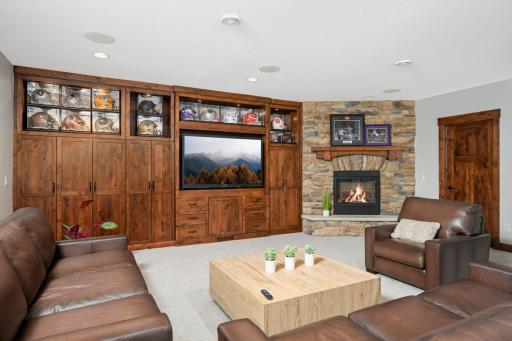Lower level family room features built-in storage and fourth gas fireplace in the home.