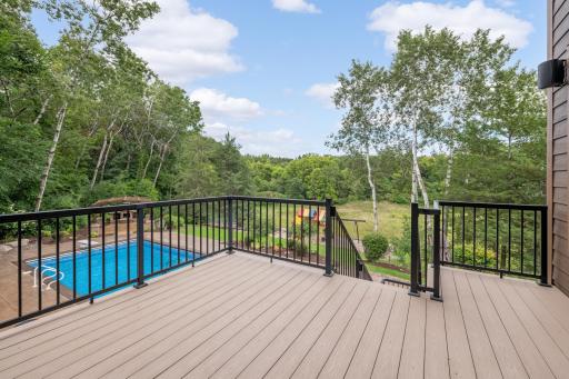 Deck off of main level with stairs leading down to pool.