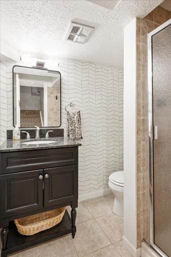 The lower level 3/4 bath has been completely updated, including a new vanity, sink, faucet and light fixture.