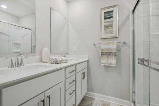 (Photo of a decorated model, actual homes finishes will vary) The primary bath is a great oasis featuring a walk in shower and double vanity!