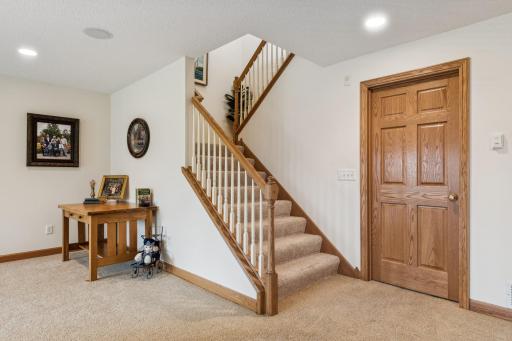 This staircase features solid oak railings & millwork, upgraded & plush neutral carpet (new in 2020), built-in art niche, and professionally painted, neutral walls.