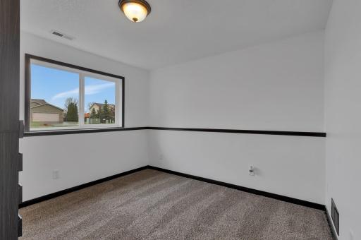 One of two bedrooms on the lower level features plush carpet, neutral colors and plenty of natural light.