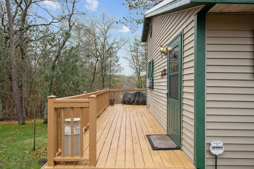 Large deck wraps around rear of home to overlook large lot and lake views