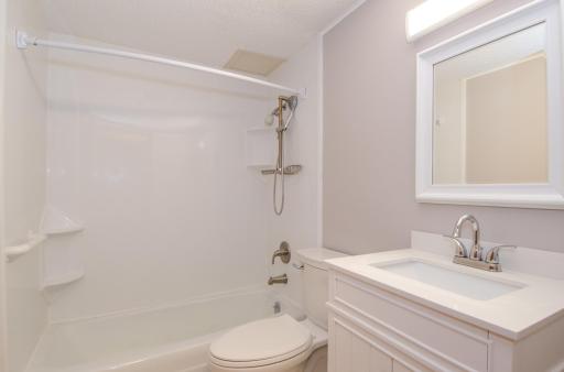 Totally updated bathroom with vanity, tub surround, comfort height toilet, and fixtures.
