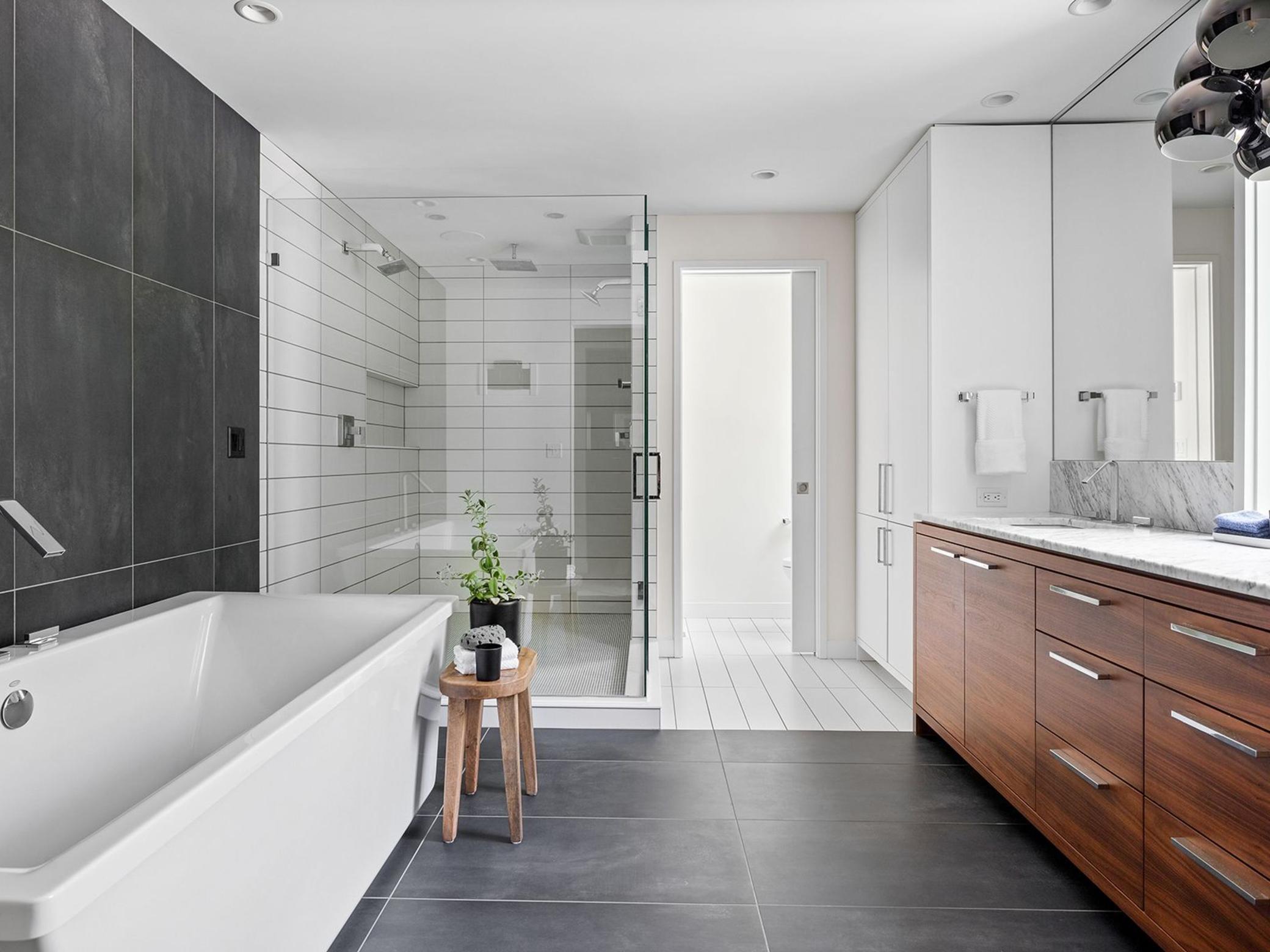 Spacious primary ensuite bath with soaking tub and luxurious, frameless glass-enclosed shower offering a spa-like experience with its sleek, minimalist design.