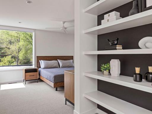 The upper-level guest suite, complete with an ensuite bathroom, is bathed in extraordinary natural light, creating an inviting and serene atmosphere.