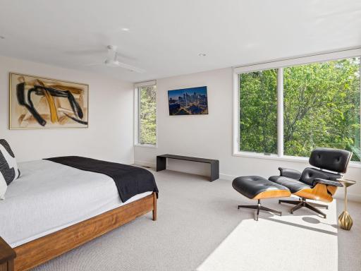 The primary bedroom boasts an abundance of natural light, accentuated by corner windows that offer captivating views of the exquisite backyard.