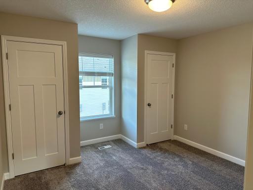 One of the bedrooms, located on the second floor and featuring 2 closets for added storage and a unique layout