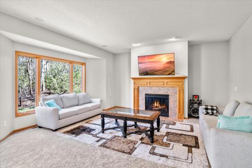 Charming living space with gas burning fireplace and nature views.