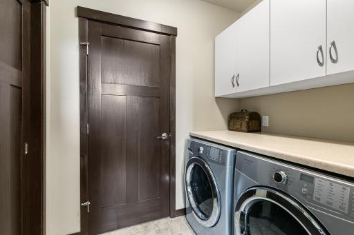 Practical laundry area with washer and dryer. Mechanicals are behind the door and you will find a lower level pantry to the left.
