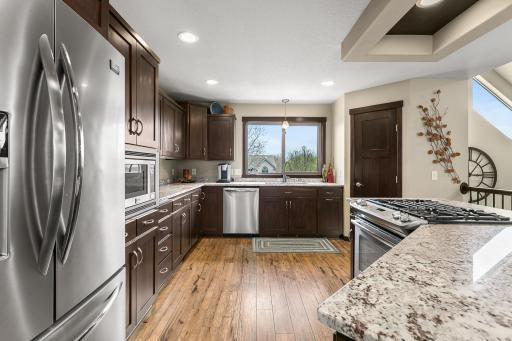 Modern kitchen equipped with stainless steel appliances, and espresso stained cabinetry. Note the gorgeous granite counters and spacious pantry.