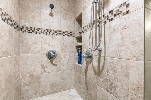 Luxurious tiled shower adds elegance to the bathroom.