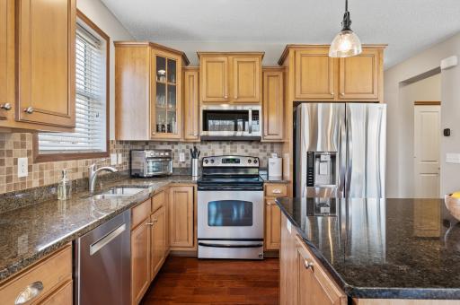 The heart of the home boasts a fantastic kitchen equipped with granite countertops, stainless steel appliances, and a large center island with breakfast bar seating.