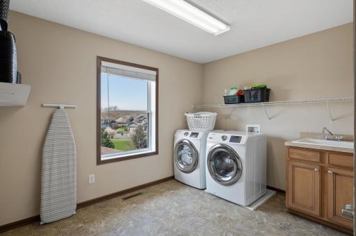 Expansive laundry room featuring extra storage and a utility sink for added functionality.