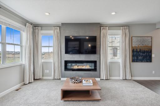 (Photo of decorated model, actual home's finishes will vary) Soaring windows provide an abundance of natural light to low throughout the main level, including this nicely sized great room, featuring an electric fireplace.