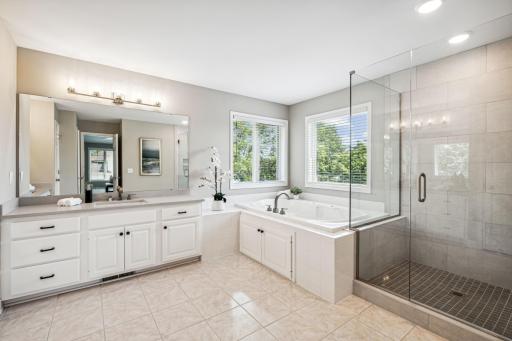 The large primary bath features a luxurious design with a separate tub and shower, offering both relaxation and convenience. Two vanities provide ample space and functionality, making it an ideal retreat for comfort and elegance.