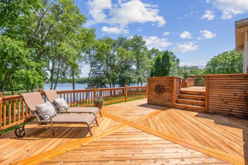 A large deck with stunning lake views offers a serene space for relaxation and entertaining. Enjoy the natural beauty and tranquility, perfect for gatherings, dining, or unwinding with a scenic backdrop.