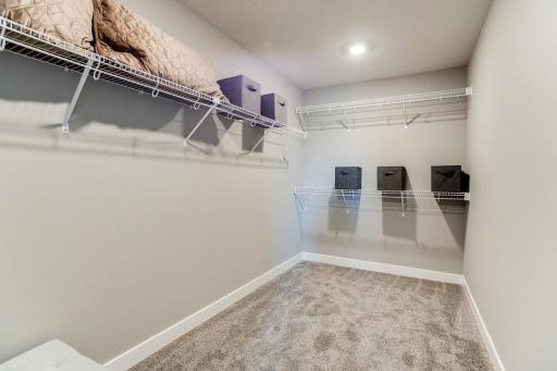 Take a look at the primary suite walk-in-closet! An impressive amount of storage! Photo of model home. Selections will differ.
