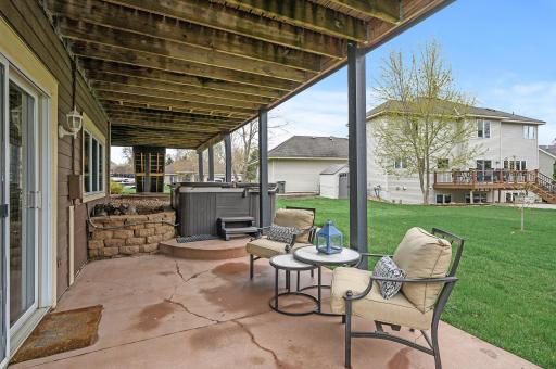 Patio walks out from the home, includes a hot tub that stays and expands into the backyard.