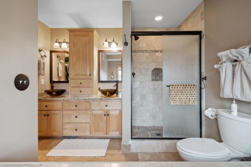 The primary suite brings dual vanities, a tiled walk-in shower and a separate jetted tub.