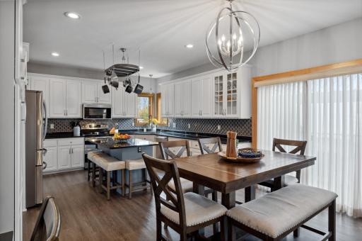 The kitchen features granite counters, a tiled backsplash, stainless appliances, a double oven, a large farm-style sink, and a large center island.