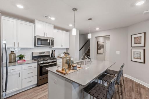 (Photo of decorated model, actual home's finishes may vary slightly) Open and inviting throughout, the stunning kitchen will be a focal point of gatherings for years to come.