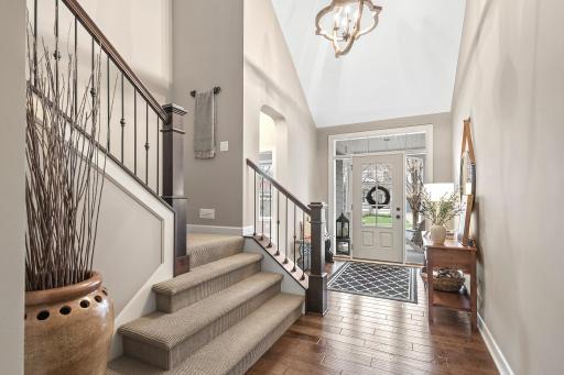 Enter through the breathtaking 2-story vaulted foyer, where gorgeous wood floors lead you throughout the main level.